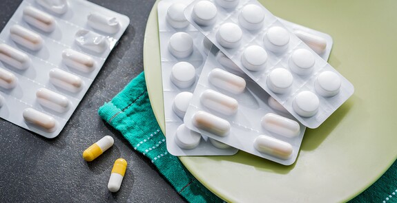Antibiotika-Tabletten gegen Bronchitis liegen auf einem Tisch.