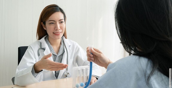 Eine Frau führt einen Lungenfunktionstest mit einem Spirometer durch