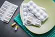Antibiotika-Tabletten gegen Bronchitis liegen auf einem Tisch.