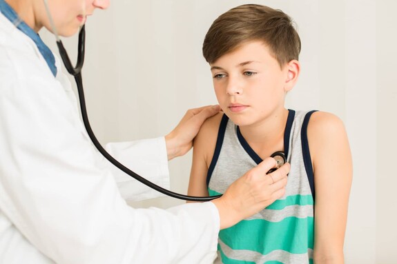 Junge mit spastischer Bronchitis wird vom Arzt untersucht.