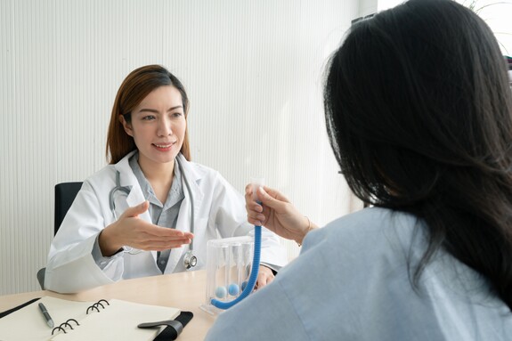 Eine Frau führt einen Lungenfunktionstest mit einem Spirometer durch