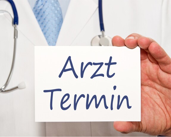 Ein Schild mit der Aufrschft "Arzt-Termin" deutet an, dass man bei langanhaltenden Beschwerden mit Schnupfen zum Arzt gehen sollte.
