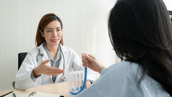 Eine Frau führt einen Lungenfunktionstest mit einem Spirometer durch